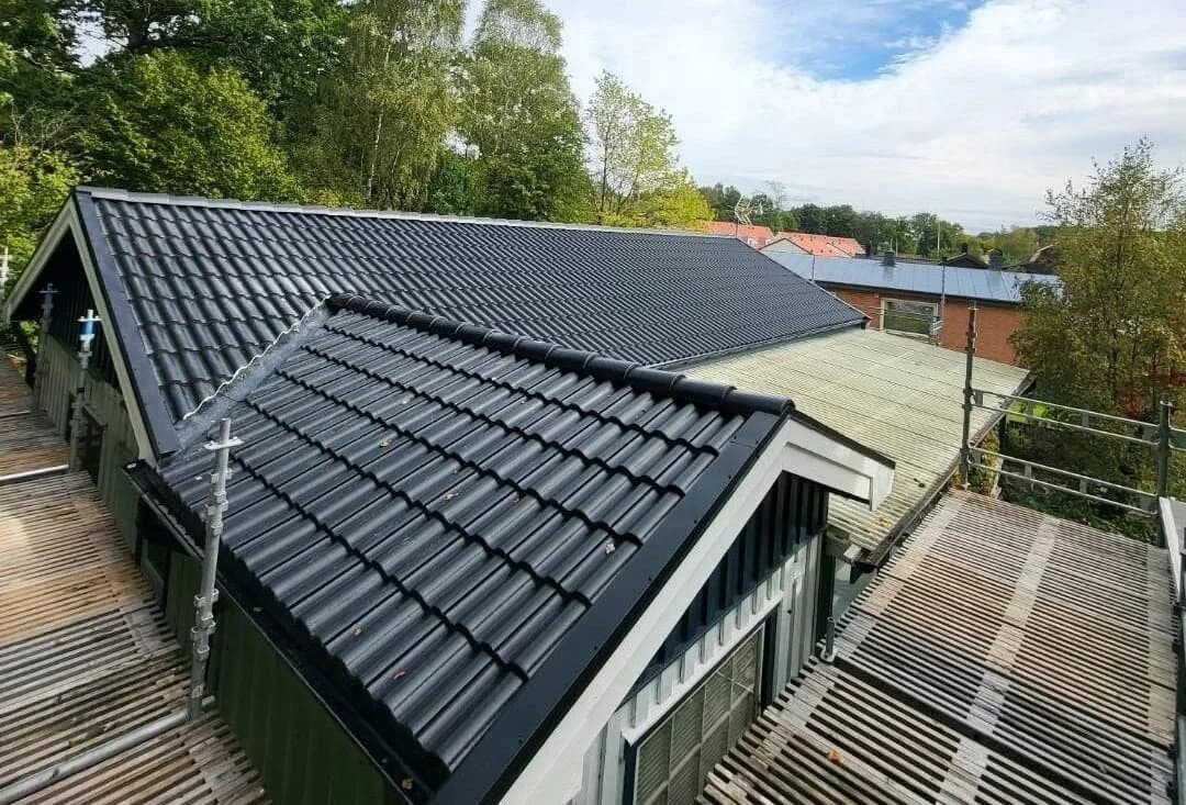 Svart tegeltak på villa med träfasad