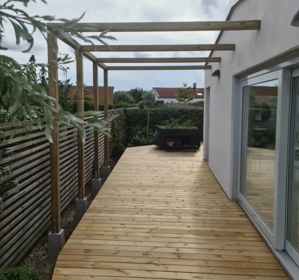 Trall och pergola längs husvägg